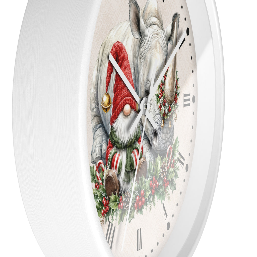 A round white wall clock with a festive printed design featuring a white rhinoceros and a Christmas gnome wearing a red hat and scarf, surrounded by candy canes, holly, and a wreath.