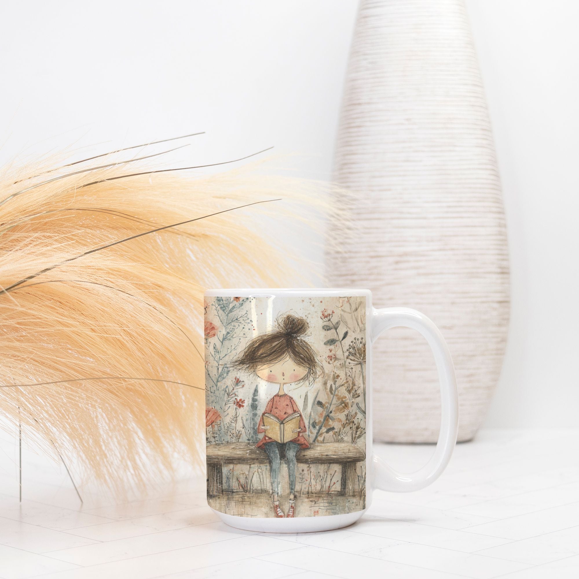 Mug with a design of a girl reading a book on a bench, placed on a light surface with decorative elements.
