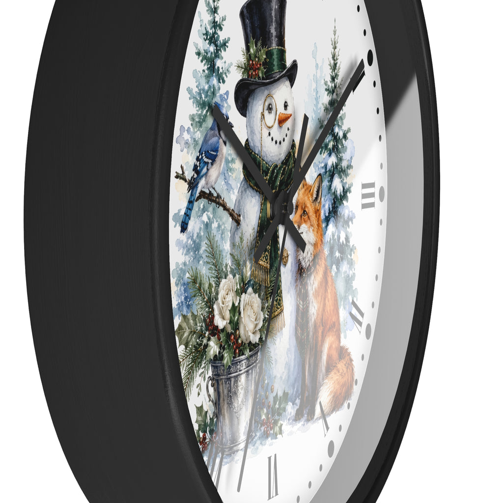 A round wall clock with a black frame and a white face featuring a winter holiday illustration of a snowman, bluebird, fox, evergreen trees, and flowers.