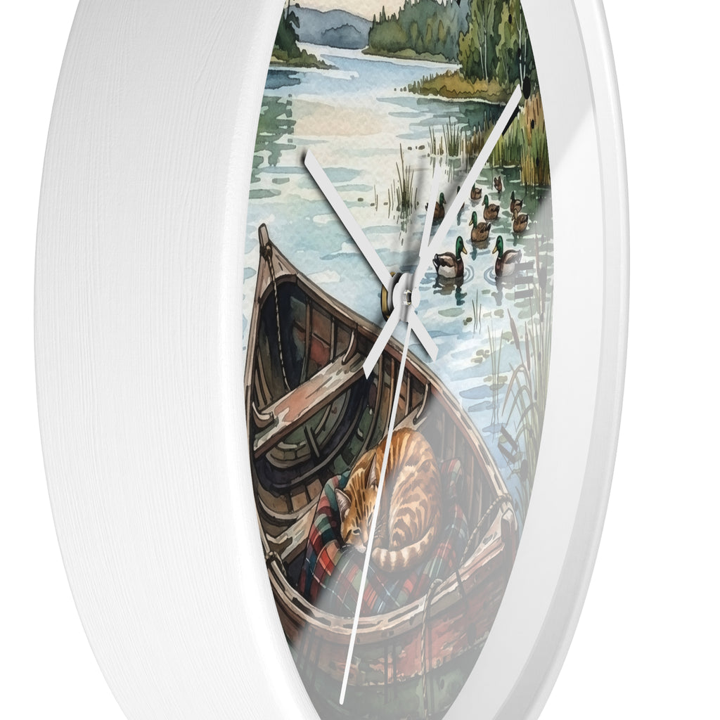 Oval white wall clock featuring a scenic illustration of a lake with ducks, a canoe, and a sleeping cat, shown against a plain white background.