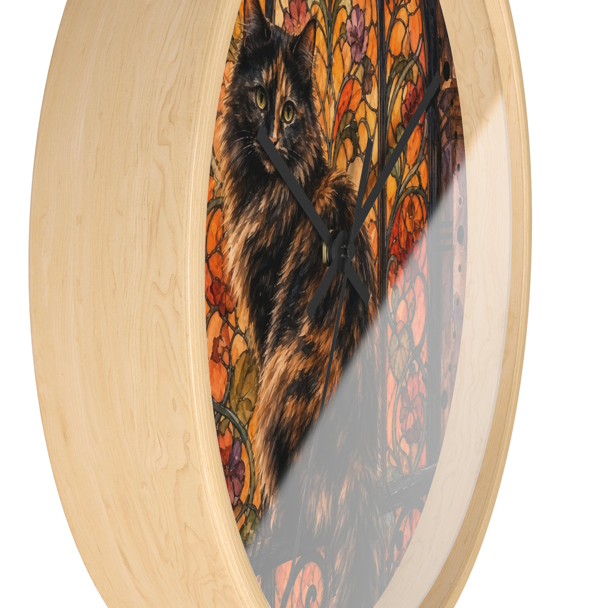 Round wall clock with a light natural wood frame and a stained-glass-style print of a black and orange cat inside, shown on a white background.