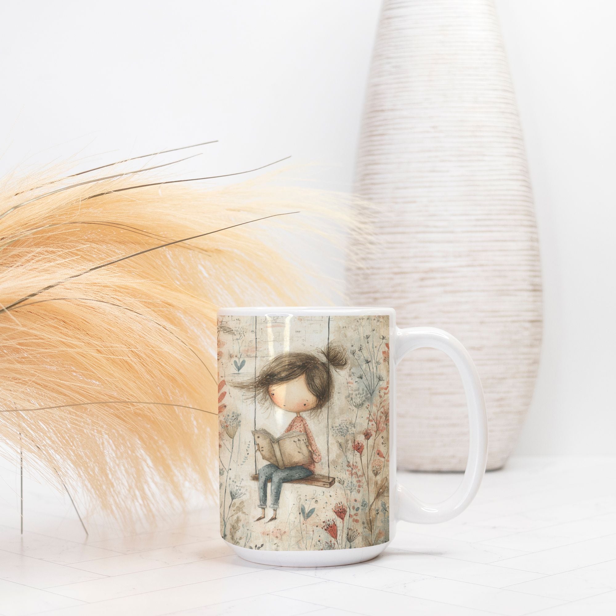 Mug with artistic design of a girl holding a book, placed on a light surface with decorative elements.