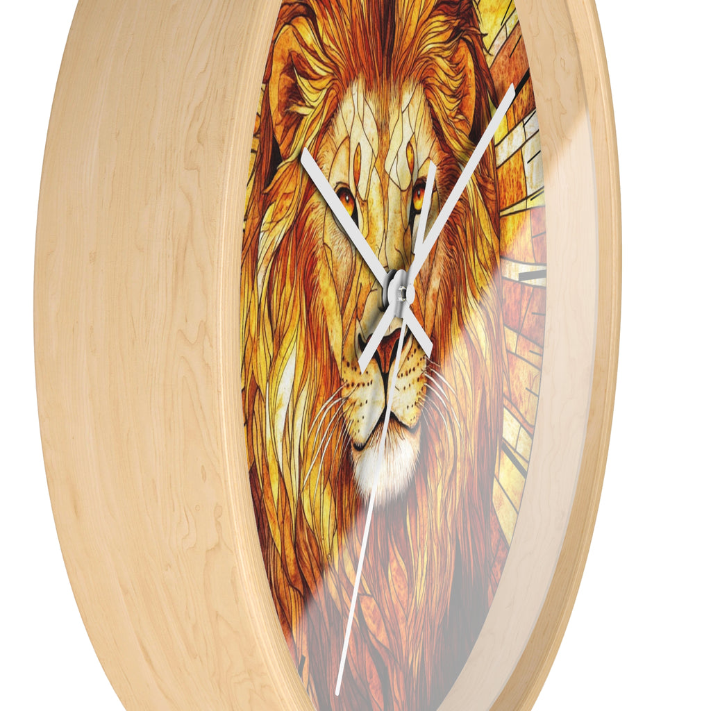 Round wall clock with a light natural wood frame and a printed lion face design in warm orange, brown, and yellow tones, with white clock hands.