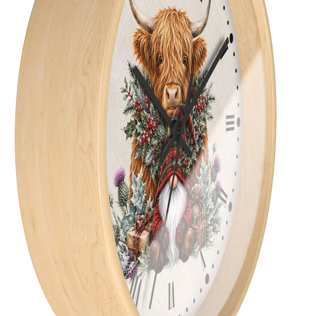 Round wall clock with a light natural wood frame and a whimsical illustration of a Highland cow wearing a red plaid scarf and green wreath, set against a clean white background.
