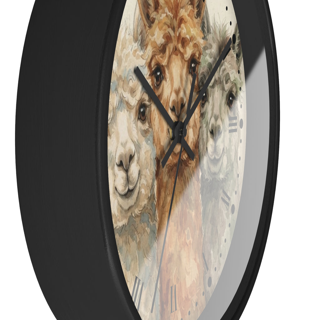 A close-up of a round wall clock with a black frame and a printed face featuring three alpaca faces in soft beige, brown, and gray tones. The clock hands and Roman numeral markers are visible against a plain light background.