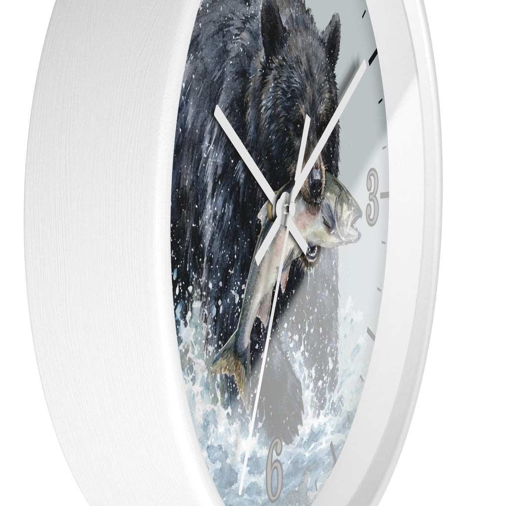 A round wall clock with a white frame and a printed design of a black bear catching a fish in splashing water, shown against a plain white background.