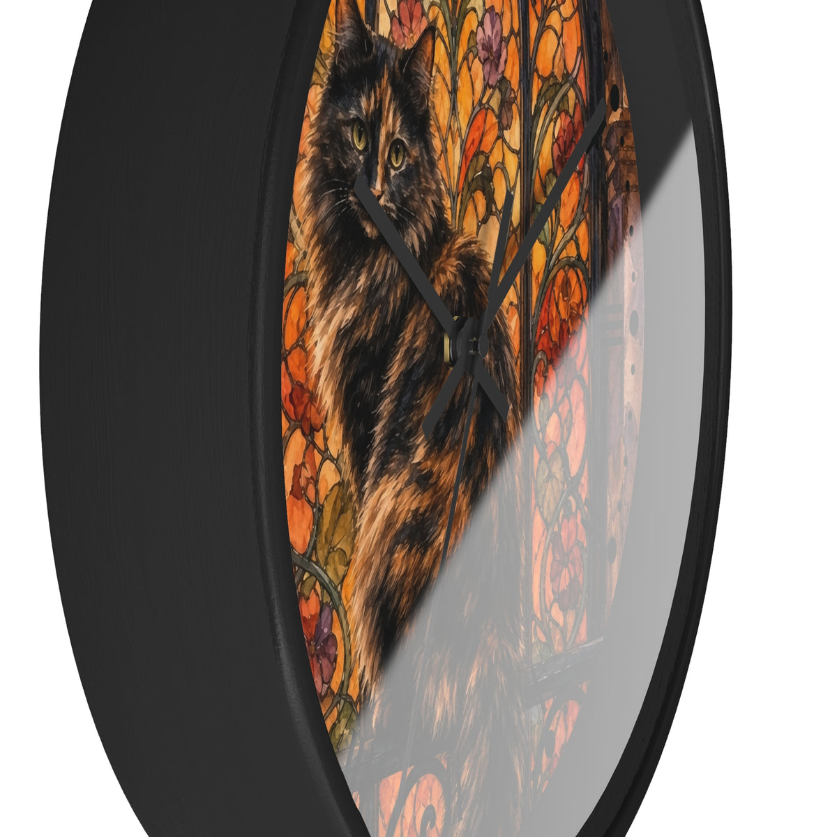 Round wall clock with a black frame and a printed design of a fluffy black-and-tan cat in front of an orange floral stained-glass style background.