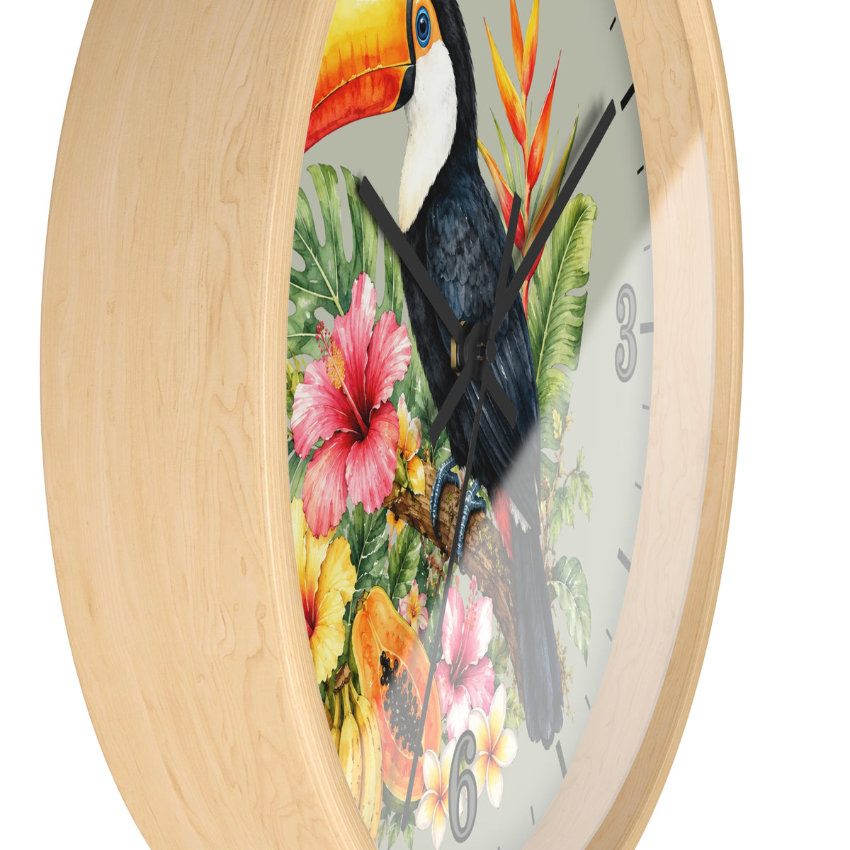 A round wall clock with a light natural wood frame and a tropical bird illustration on the face. The design features a toucan, colorful hibiscus flowers, and green leaves on a white background, with black hands and partial gray numbers visible.