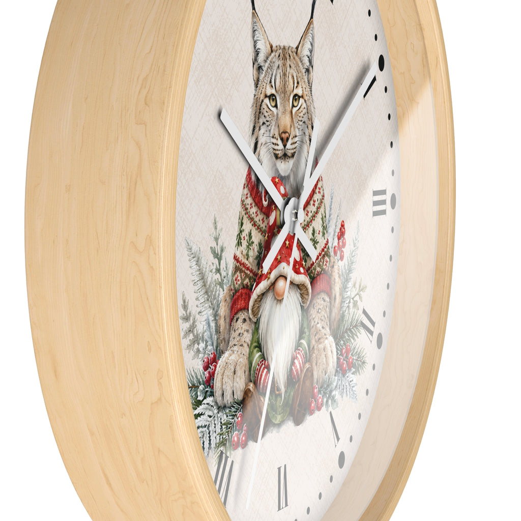 A round wall clock with a light natural wood frame and a white clock face featuring an illustration of a lynx wearing a red knit sweater and a white beard, surrounded by winter foliage.