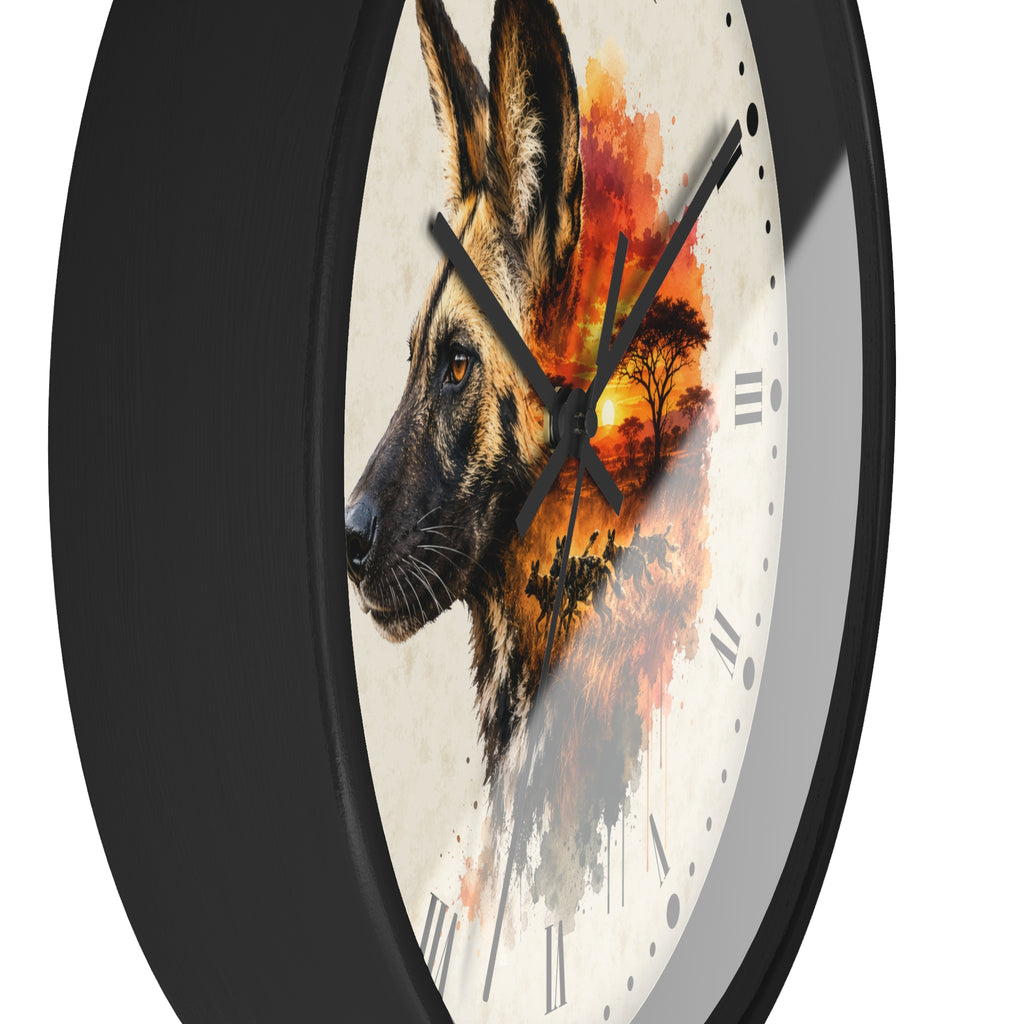 A round wall clock with a black frame and a white face featuring a watercolor-style African wild dog portrait blended with an orange sunset landscape and tree silhouette.
