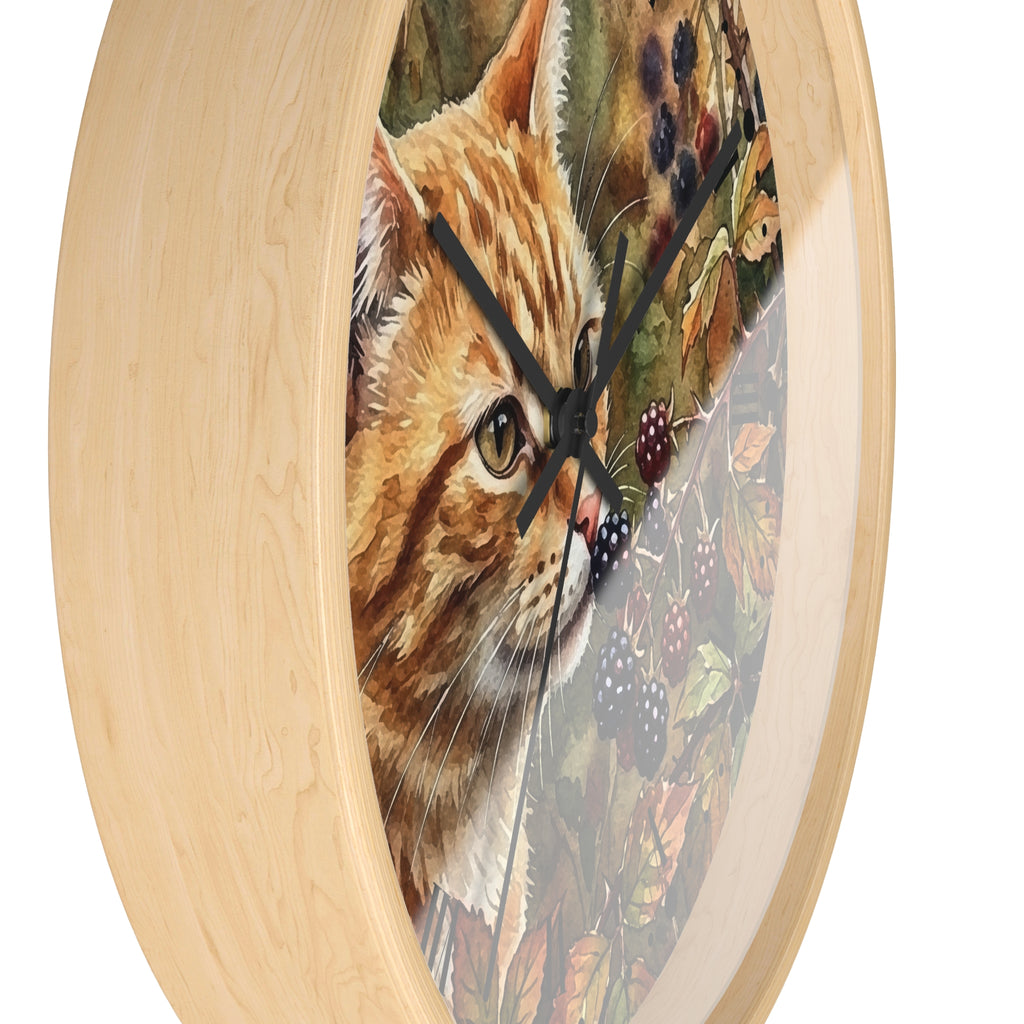 Round wall clock with a light natural wood frame and a printed illustration of an orange tabby cat over a background of berries and autumn leaves.