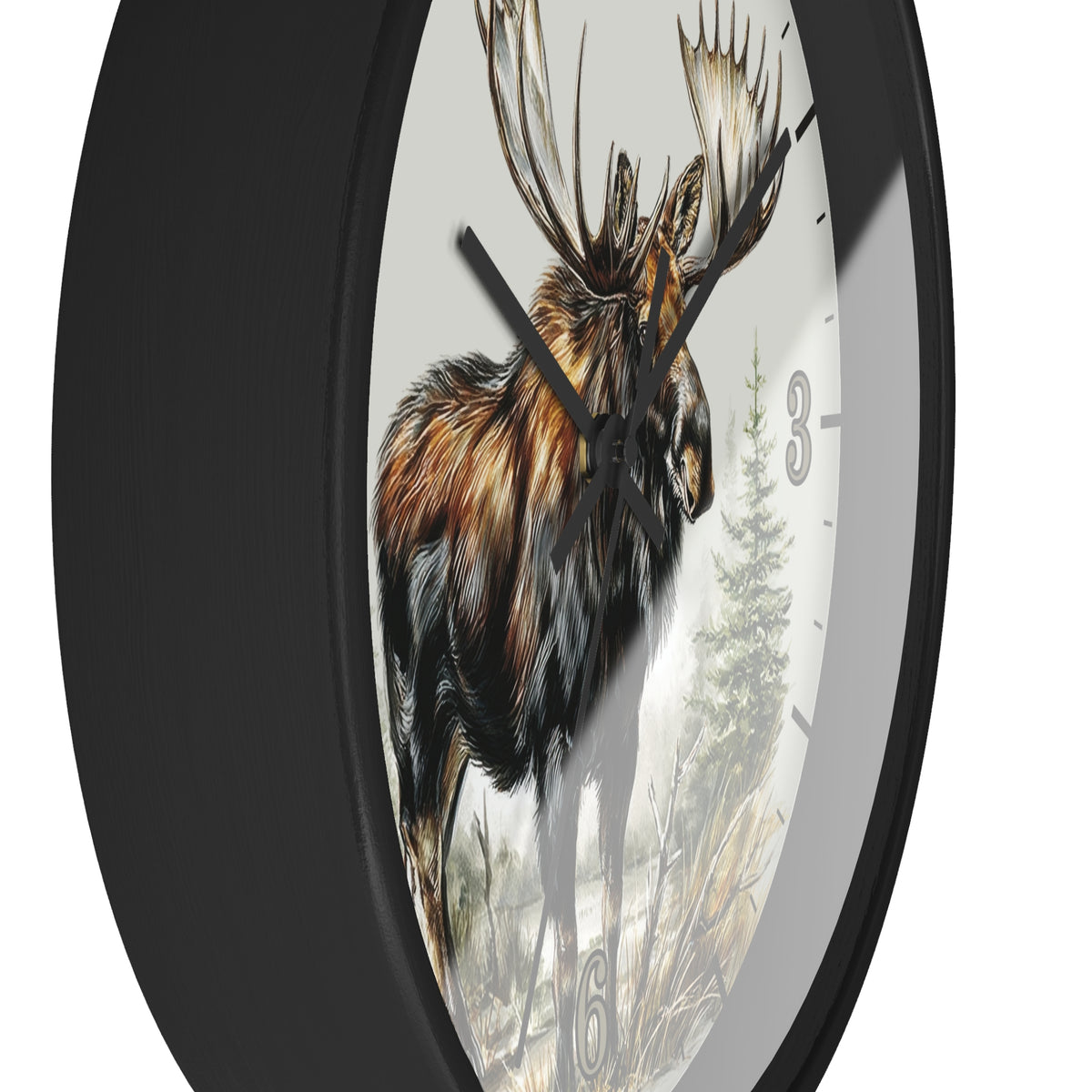 A round wall clock with a black frame and a printed nature scene on the face showing a moose, trees, and dry grass, with black hands and partial black numerals.