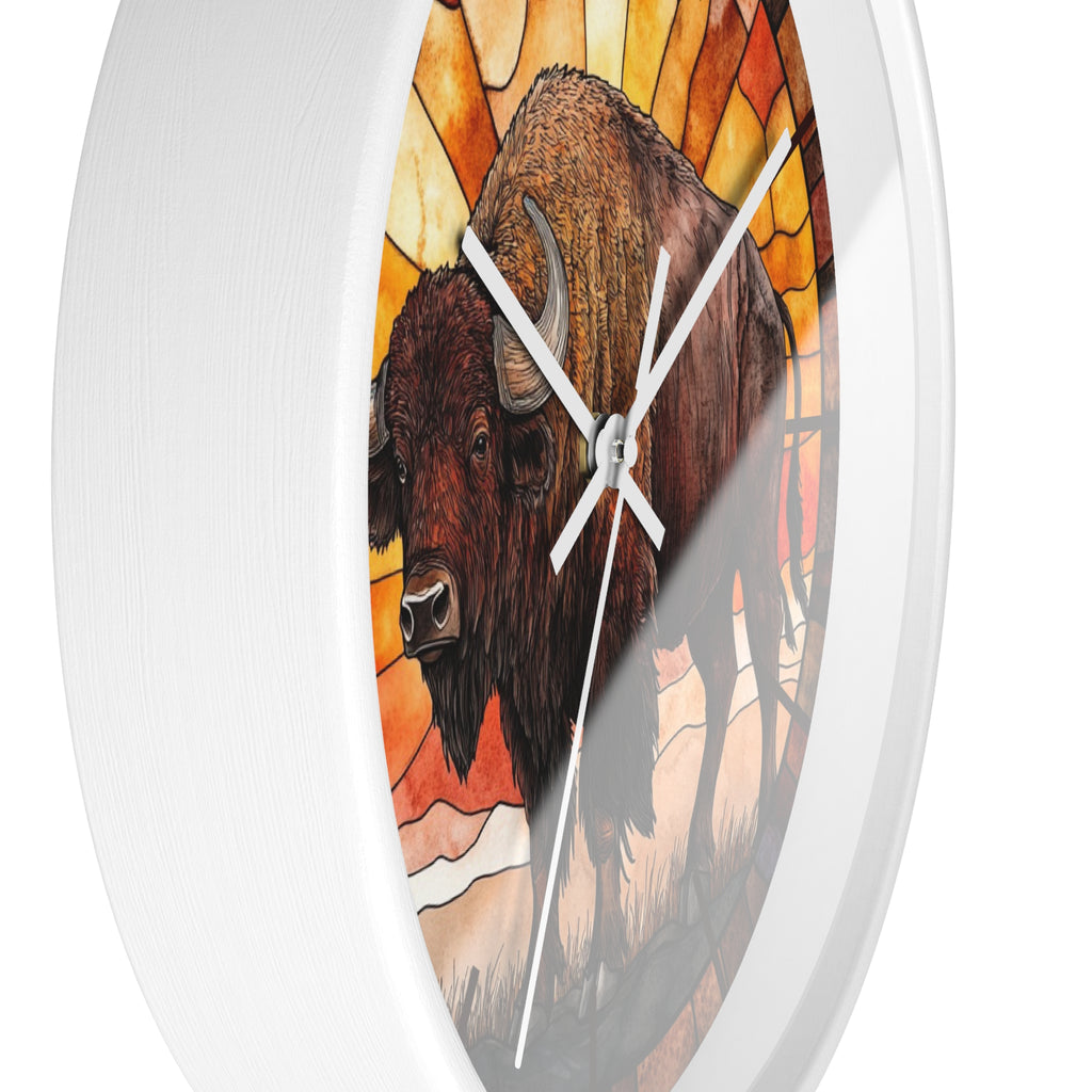 A round wall clock with a white frame and a stained-glass-style illustration of a bison in warm orange, yellow, and brown tones. The clock is shown against a plain white background.