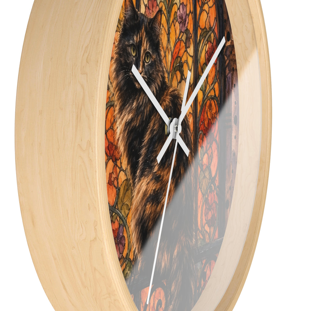 Round wall clock with a light natural wood frame and a printed artwork insert featuring a black-and-brown cat over a colorful floral background, shown against a white studio background.