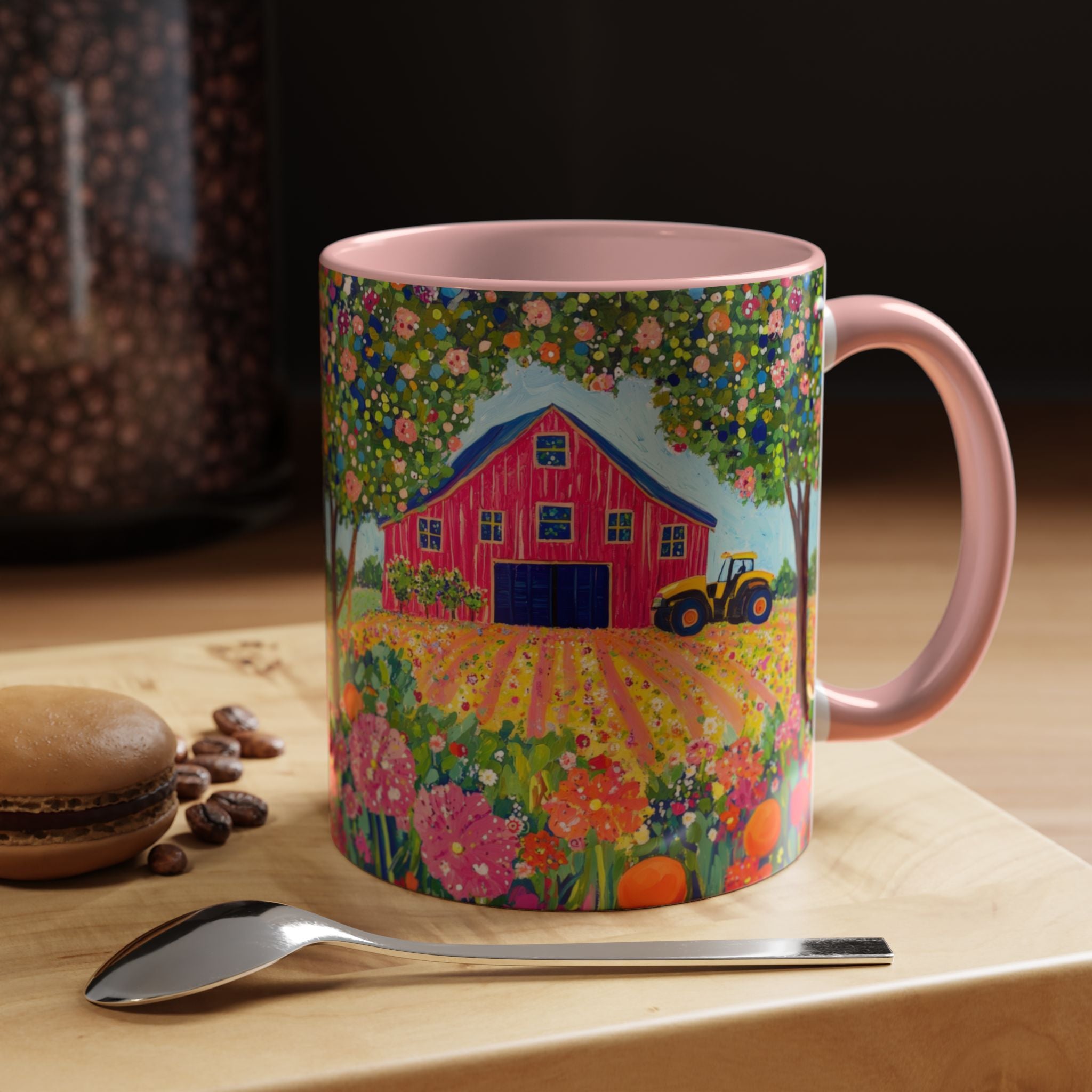 Mug with a colorful farm design on a wooden surface with coffee beans and a macaron.