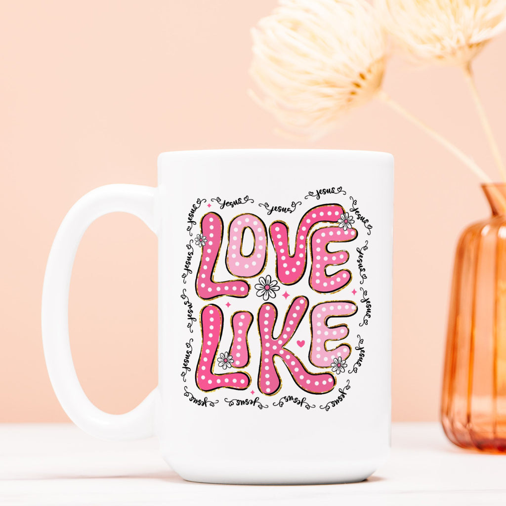 White mug with pink 'LOVE LIKE' text on a light pink background