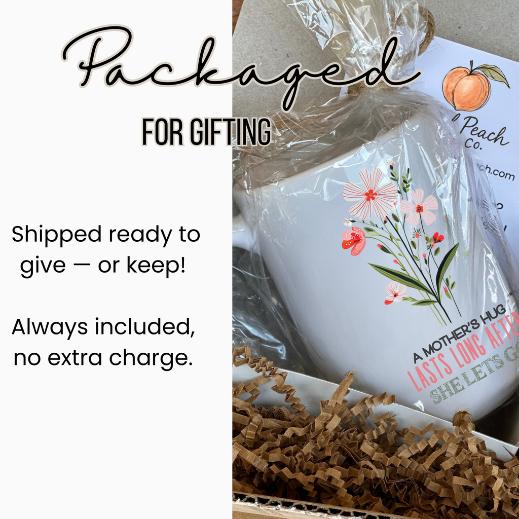 White 15oz mug with floral design and text, wrapped in clear plastic inside a white gift box with brown paper, labeled Packaged For Gifting