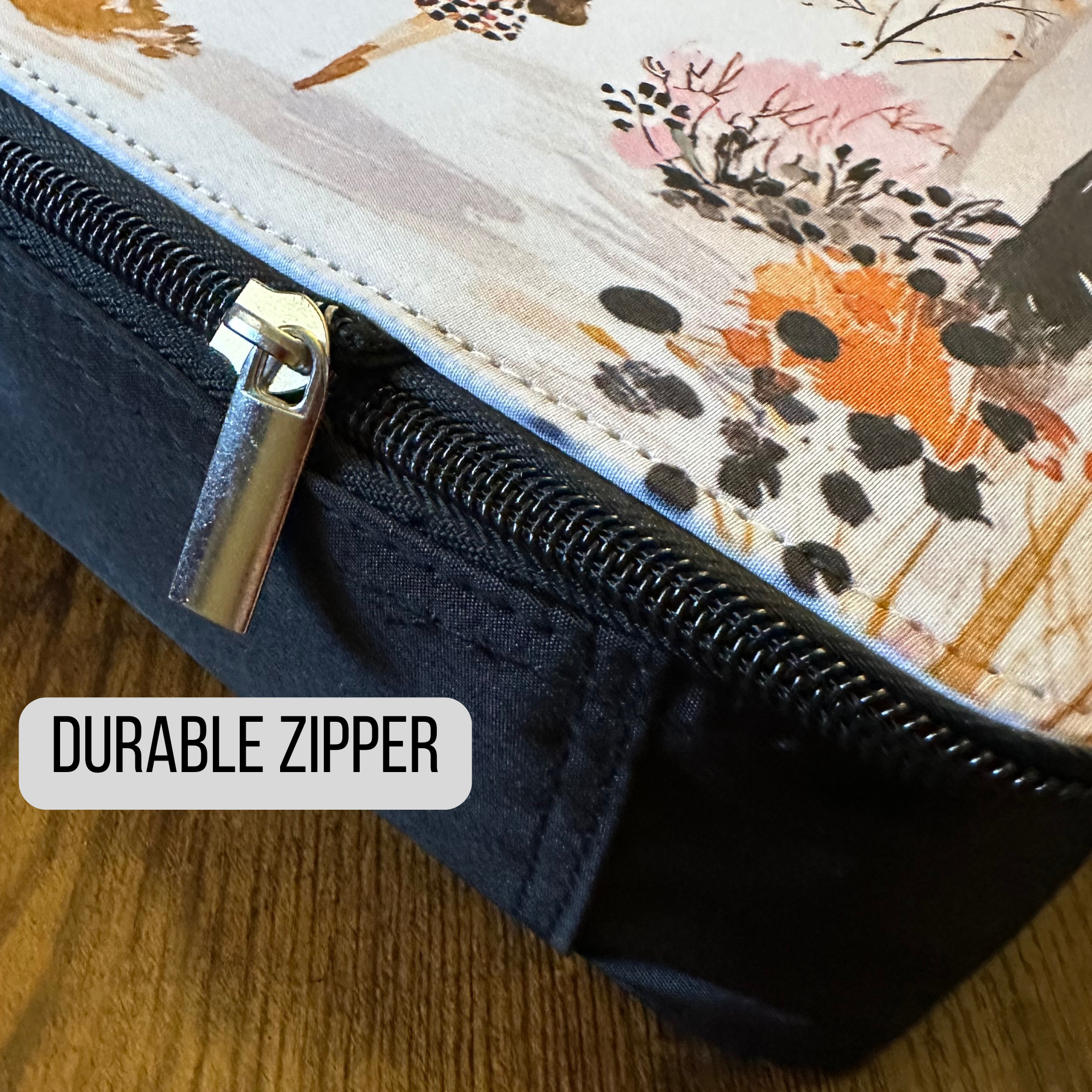 Close-up of a durable zipper on a floral-patterned lunch bag with a wooden surface background.