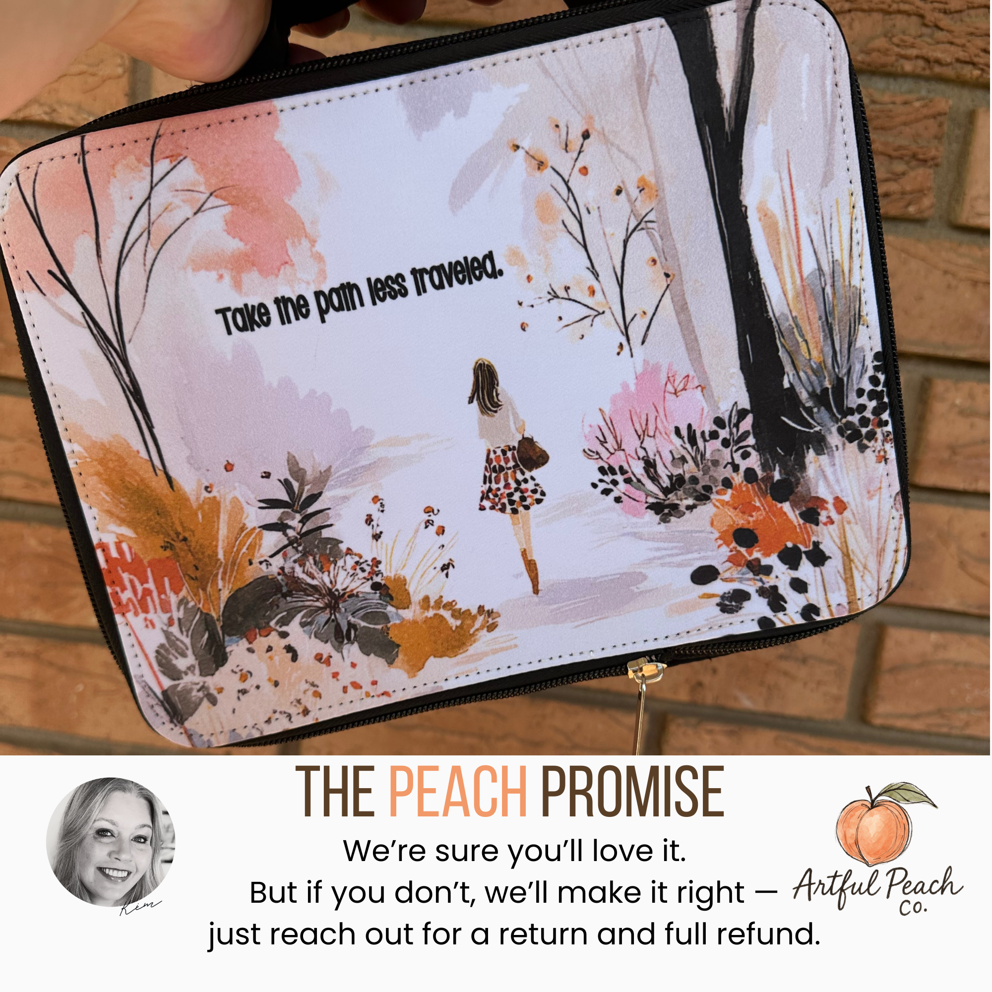 Handheld insulated lunch bag with artistic design and text 'Take the path less traveled' with a brick background.
