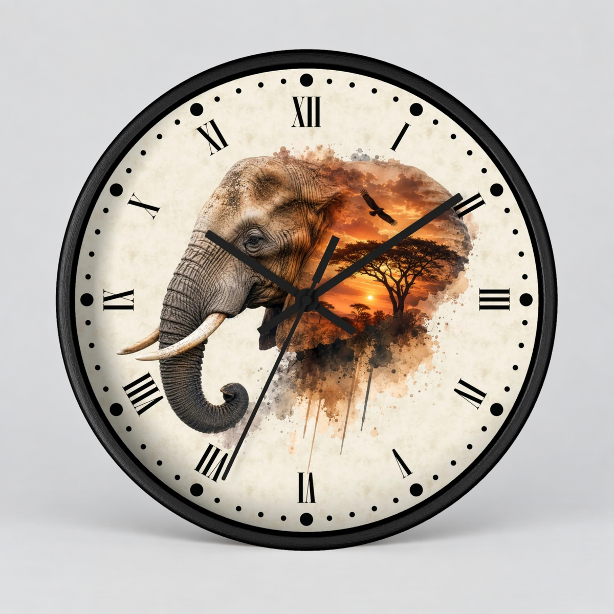 A round wall clock with a black frame and Roman numerals, featuring a watercolor-style illustration of an elephant over an African savanna sunset scene on the clock face, shown against a light gray background.
