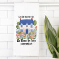 Decorative towel with a house and floral design on a white tiled background