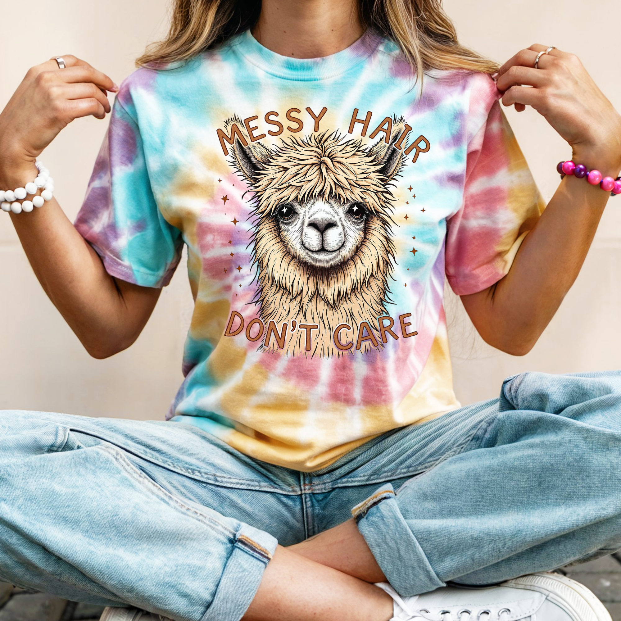 Person wearing a tie-dye t-shirt with a llama graphic and 'Messy Hair Don't Care' text.