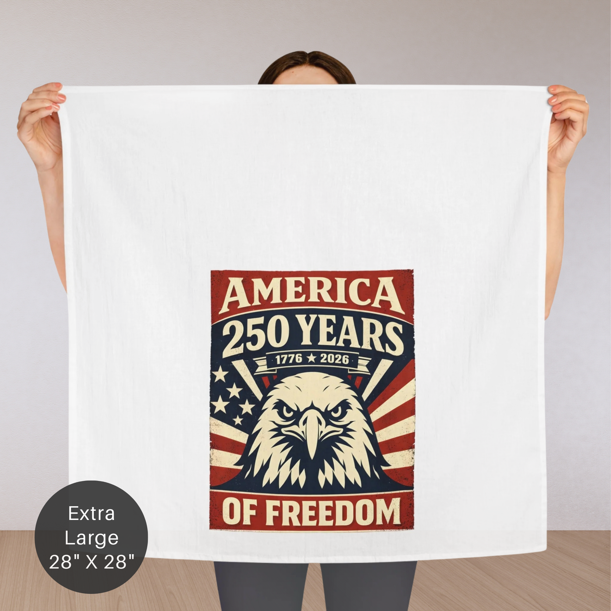 Person holding an extra large tea towel with an eagle design and text celebrating America's 250 years of freedom.