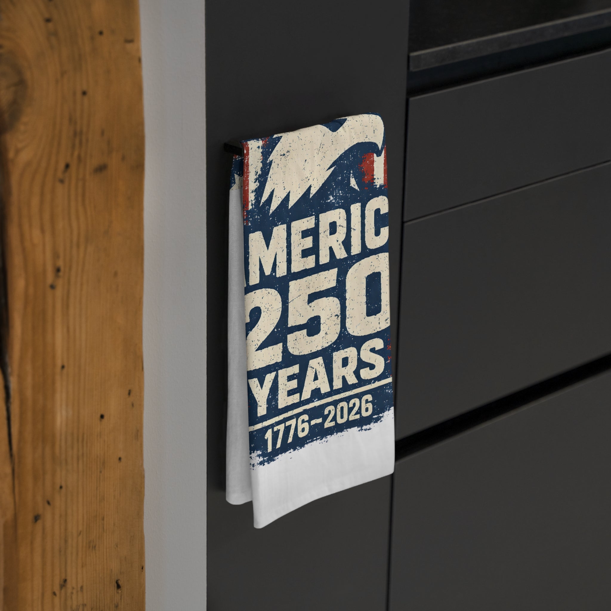 Tea towel celebrating 250 years of 'America' on a surface with wooden and black background.