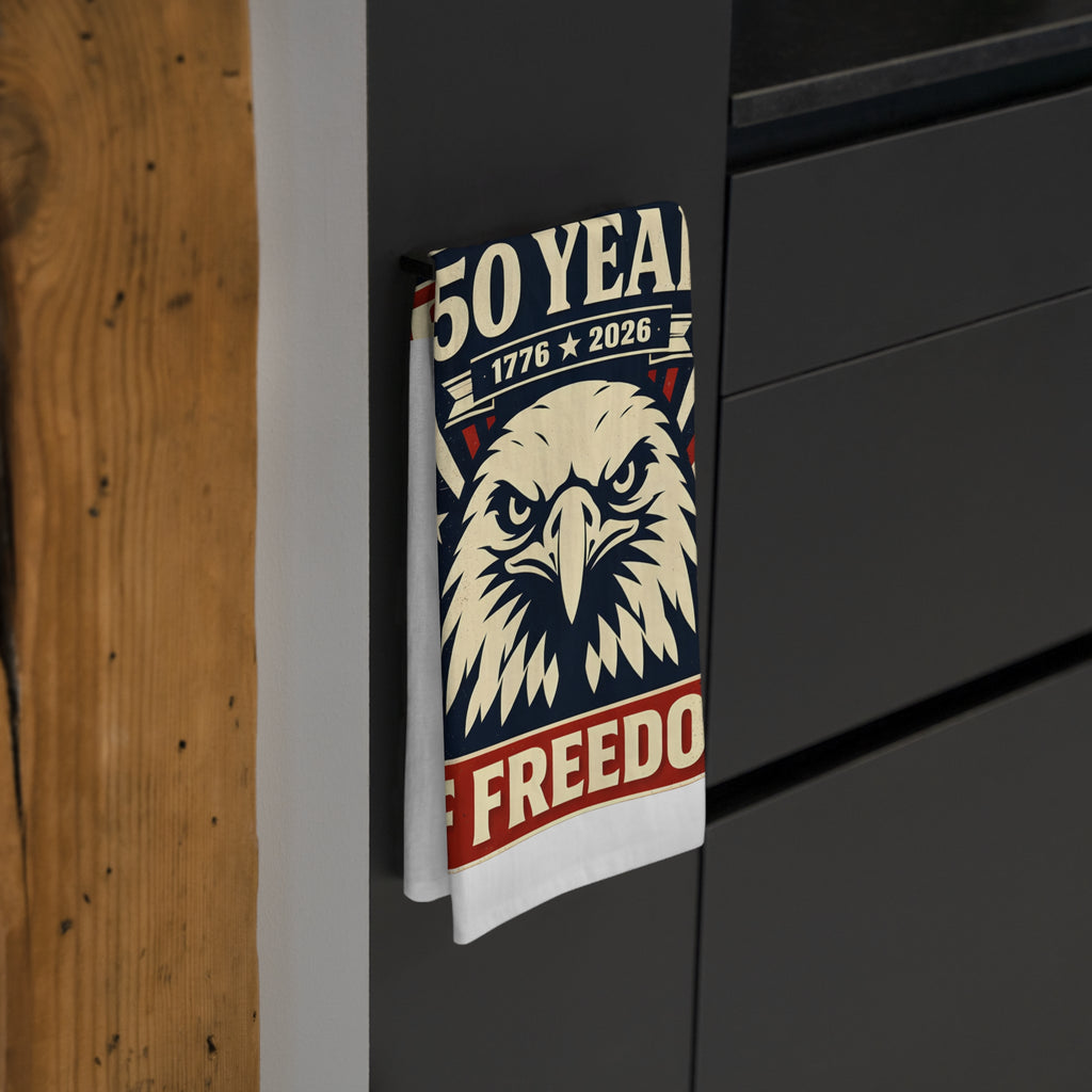 Tea towel with an eagle design and text hanging on a dark wooden cabinet
