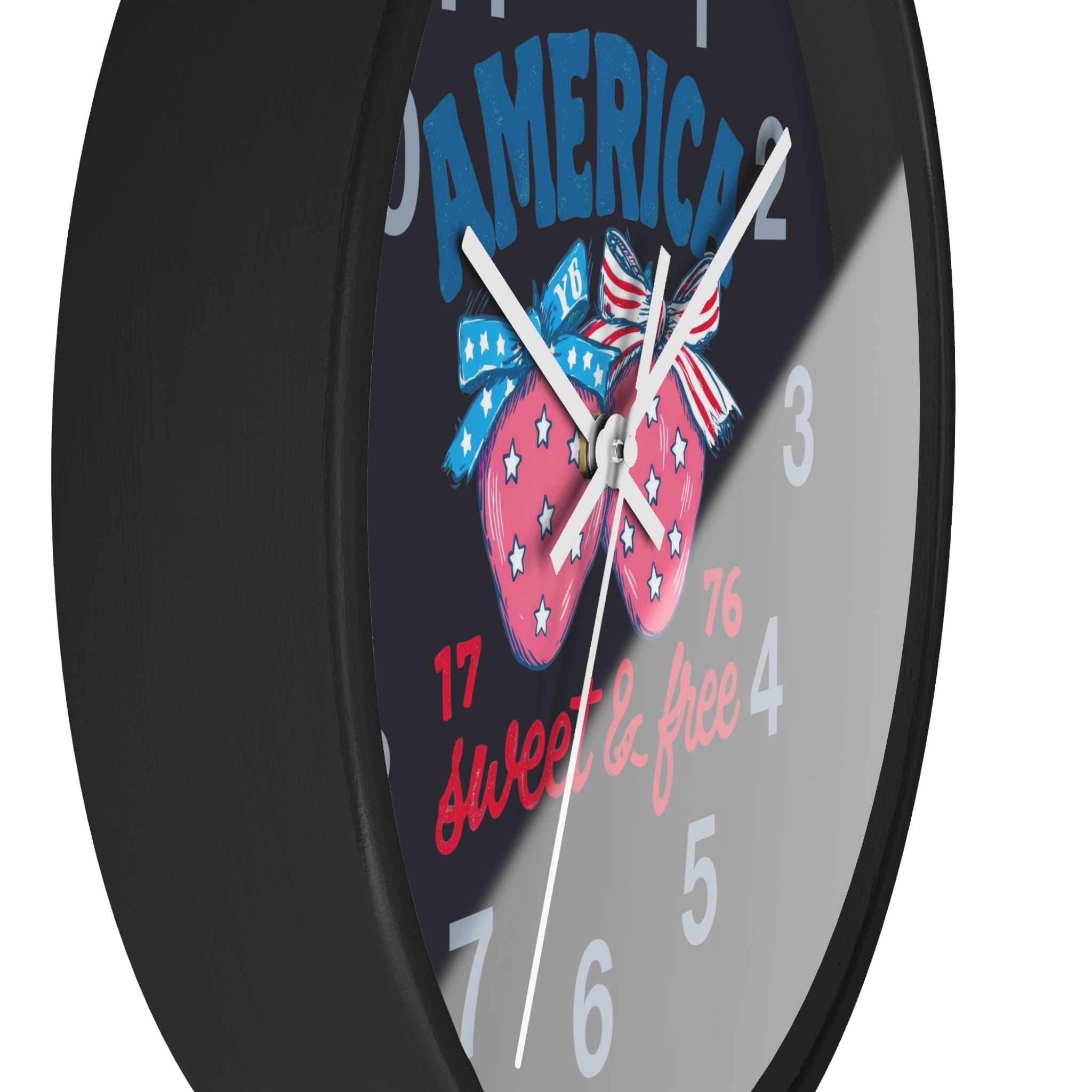 Side view of a round black wall clock with white hands and patriotic design featuring strawberries and text on a black background