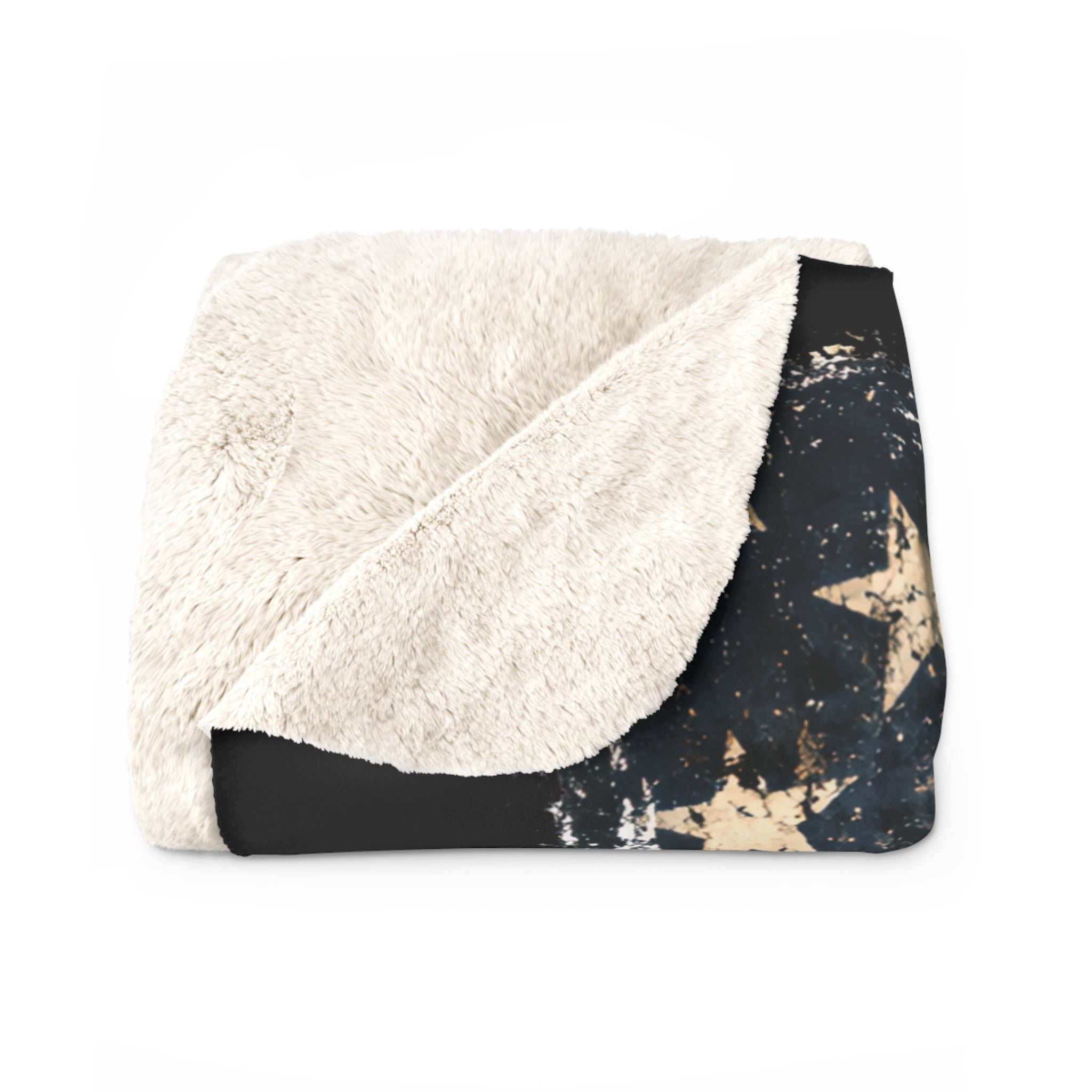 Folded blanket with white sherpa side and black star pattern on a white background
