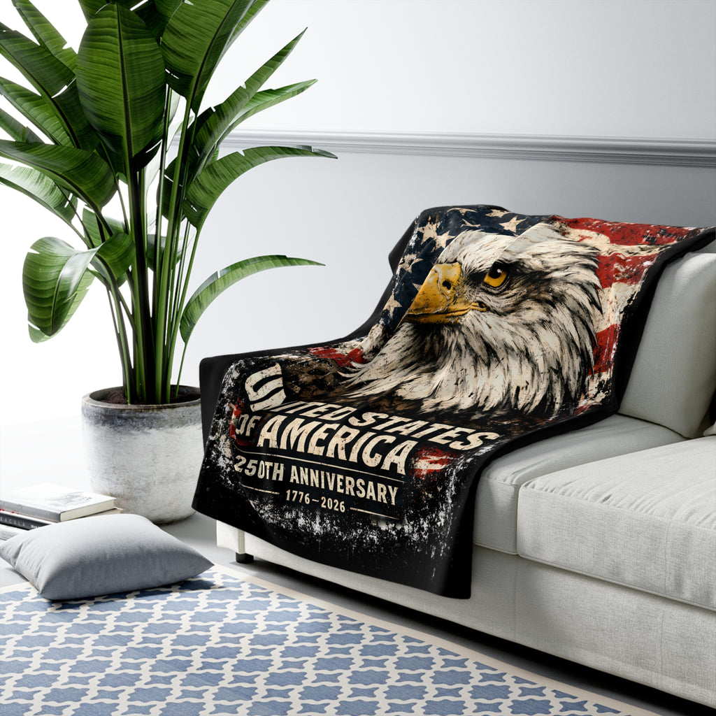 Blanket with an eagle design featuring 'United States of America 250th Anniversary' on a couch in a living room.