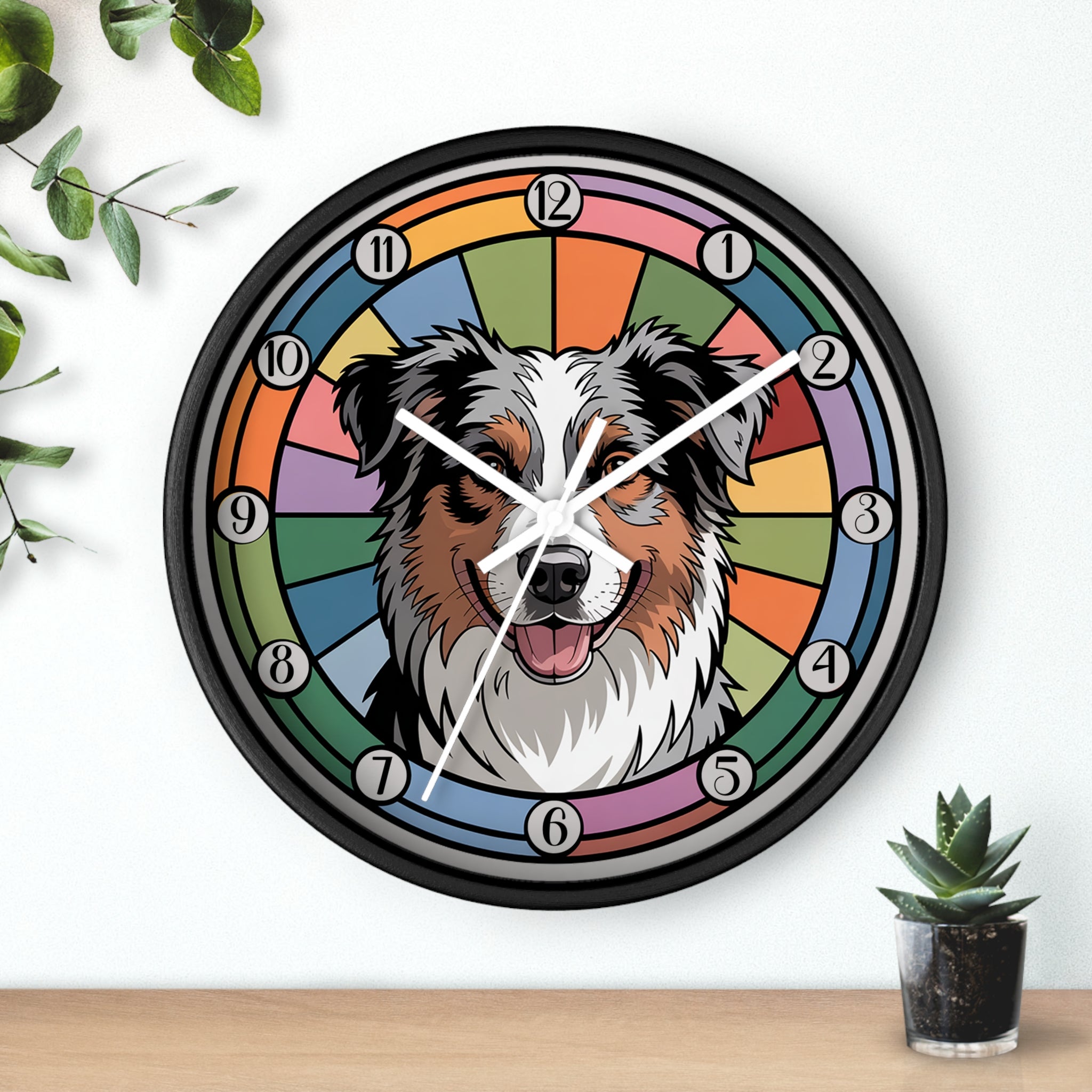 Round black wall clock with a dog's face design on a colorful background, placed on a wooden surface with plants.