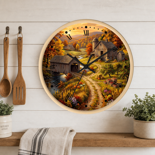 Round wall clock with a rustic barn and fall landscape print, mounted on a white wood plank wall above a shelf with kitchen utensils and plants.