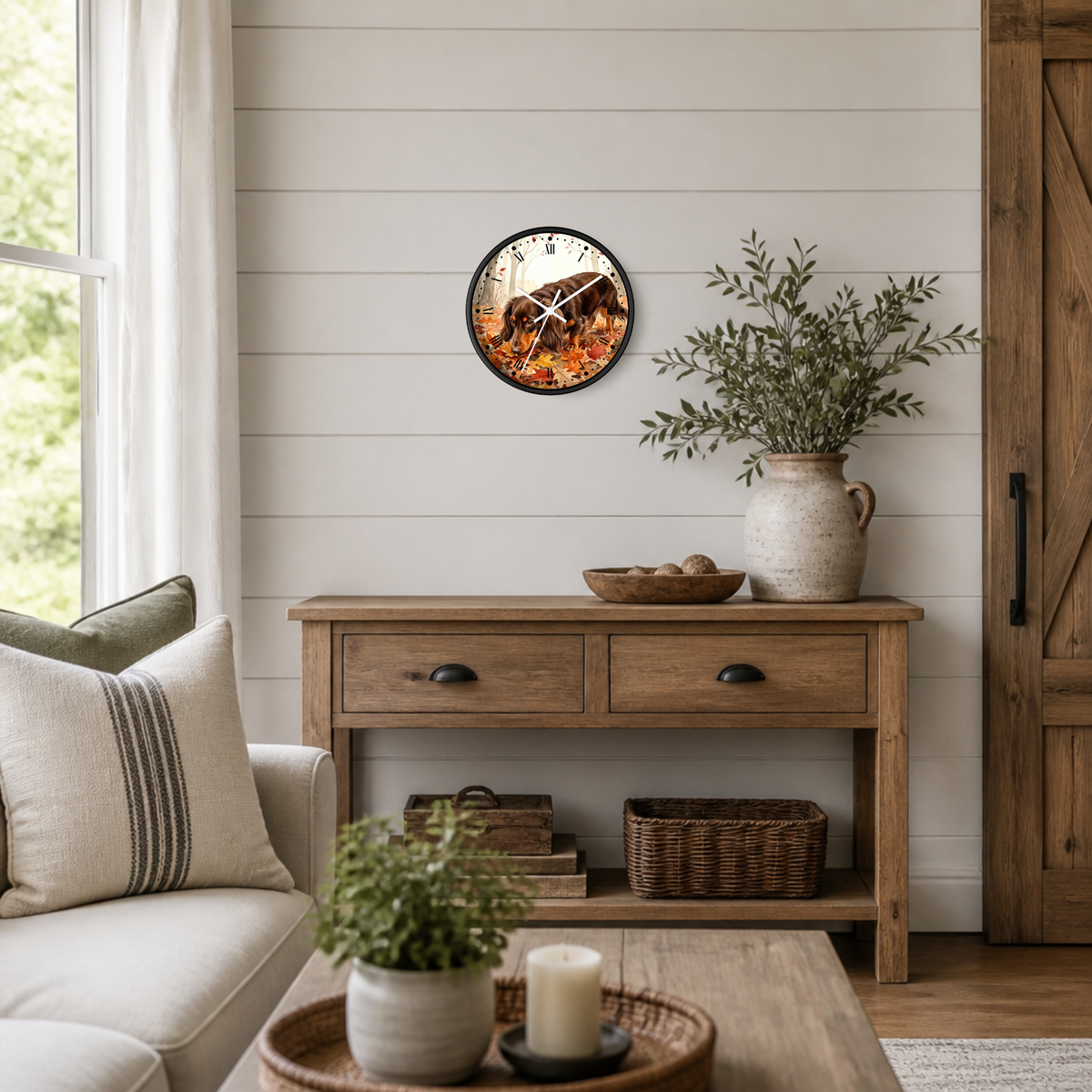 A round wall clock with a rustic wood-burning fire design, hanging on a white shiplap wall above a wooden console table in a styled living room.