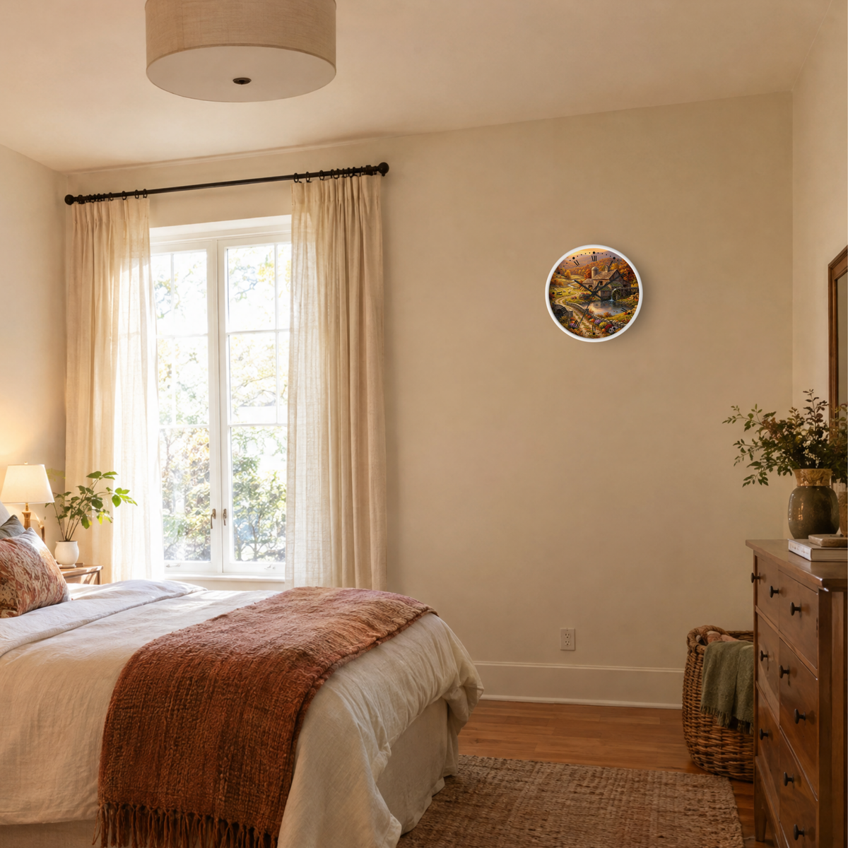 A round wall clock with an outdoor forest scene print, mounted on a beige wall in a styled bedroom with a bed, window, and wooden dresser.