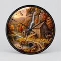 Round wall clock with a black frame and hands, featuring a detailed autumn landscape illustration with a waterfall, rustic barn, stone bridge, pumpkins, and fall foliage on a light gray background.