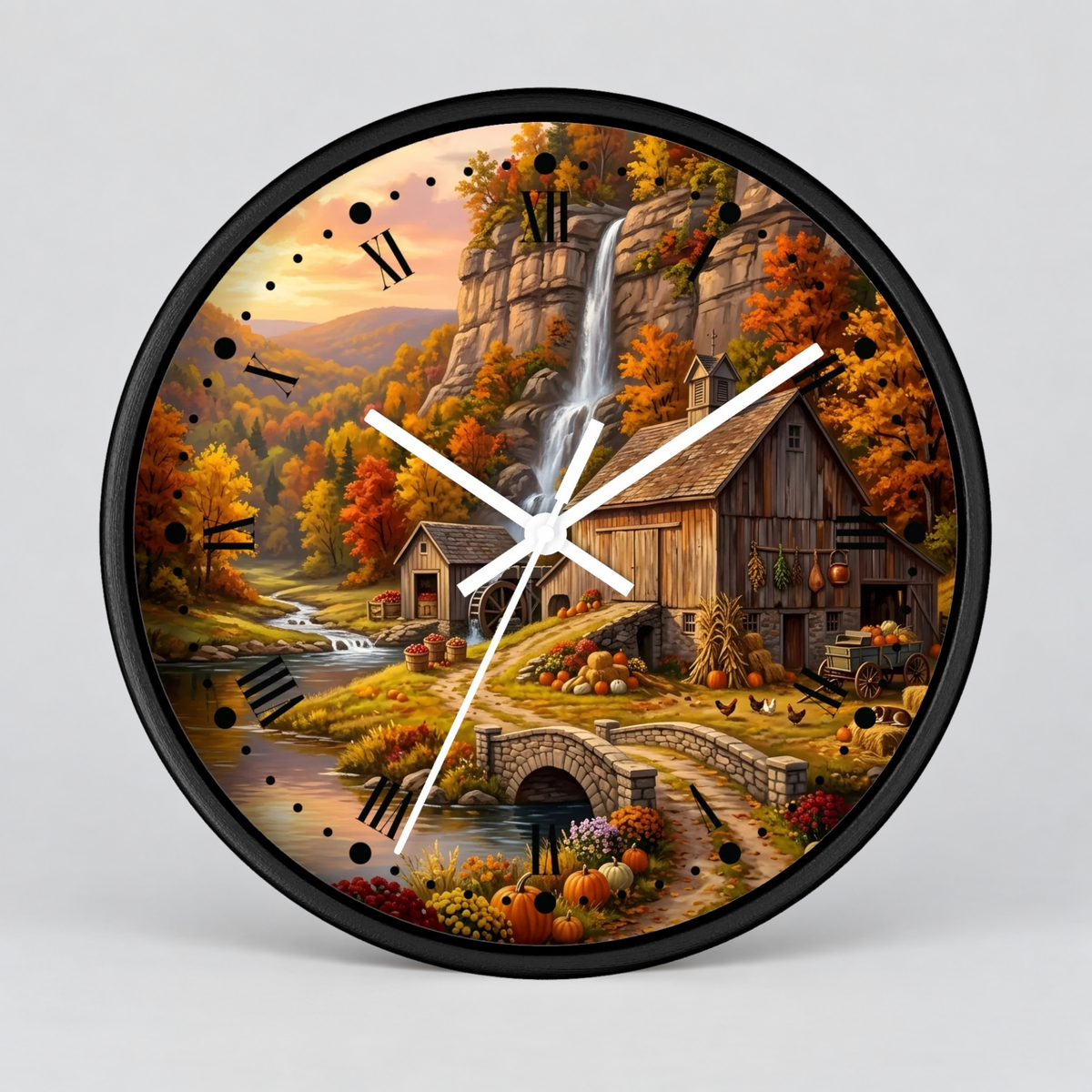 Round wall clock with a black frame and white hands, featuring a colorful autumn landscape illustration with a waterfall, barn, bridge, pumpkins, and fall foliage on a light gray background.