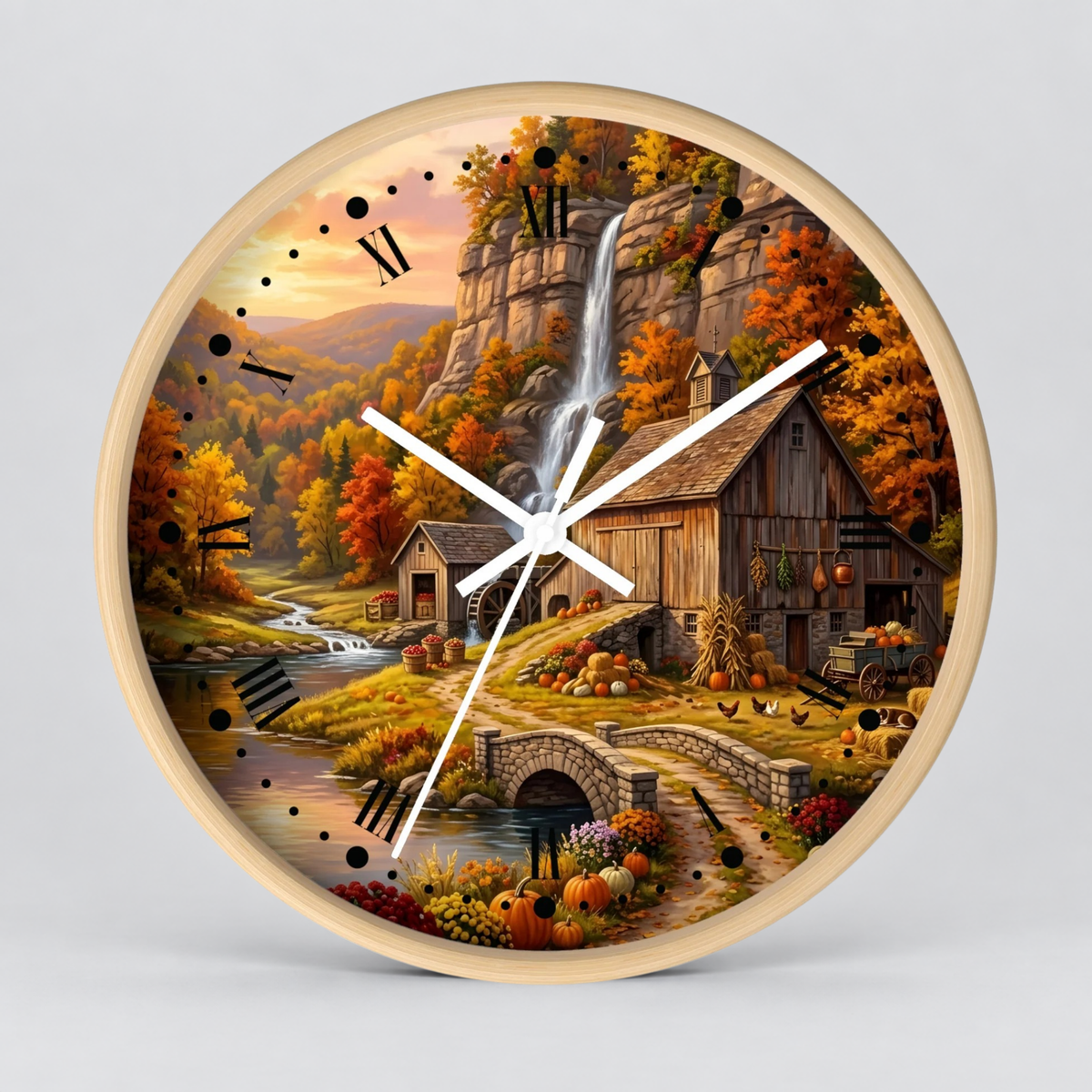 Round wall clock with a light wood frame and a printed autumn landscape scene featuring a waterfall, rustic barn, stone bridge, stream, and fall foliage. White clock hands and black Roman numerals are visible against a light gray background.