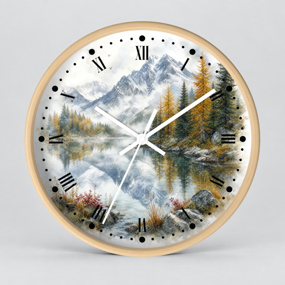 Round wall clock with a light wood frame and a scenic landscape print featuring mountains, pine trees, a reflective lake, and Roman numerals on the dial, shown against a light gray background.