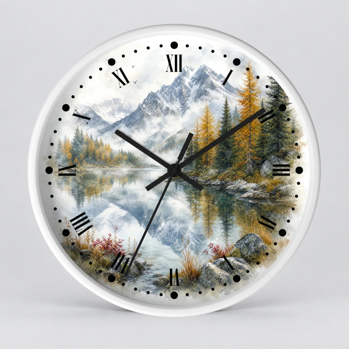 A round wall clock with a white frame and a scenic landscape print featuring snow-capped mountains, pine trees, a reflective lake, and black Roman numerals and hands on a light gray background.