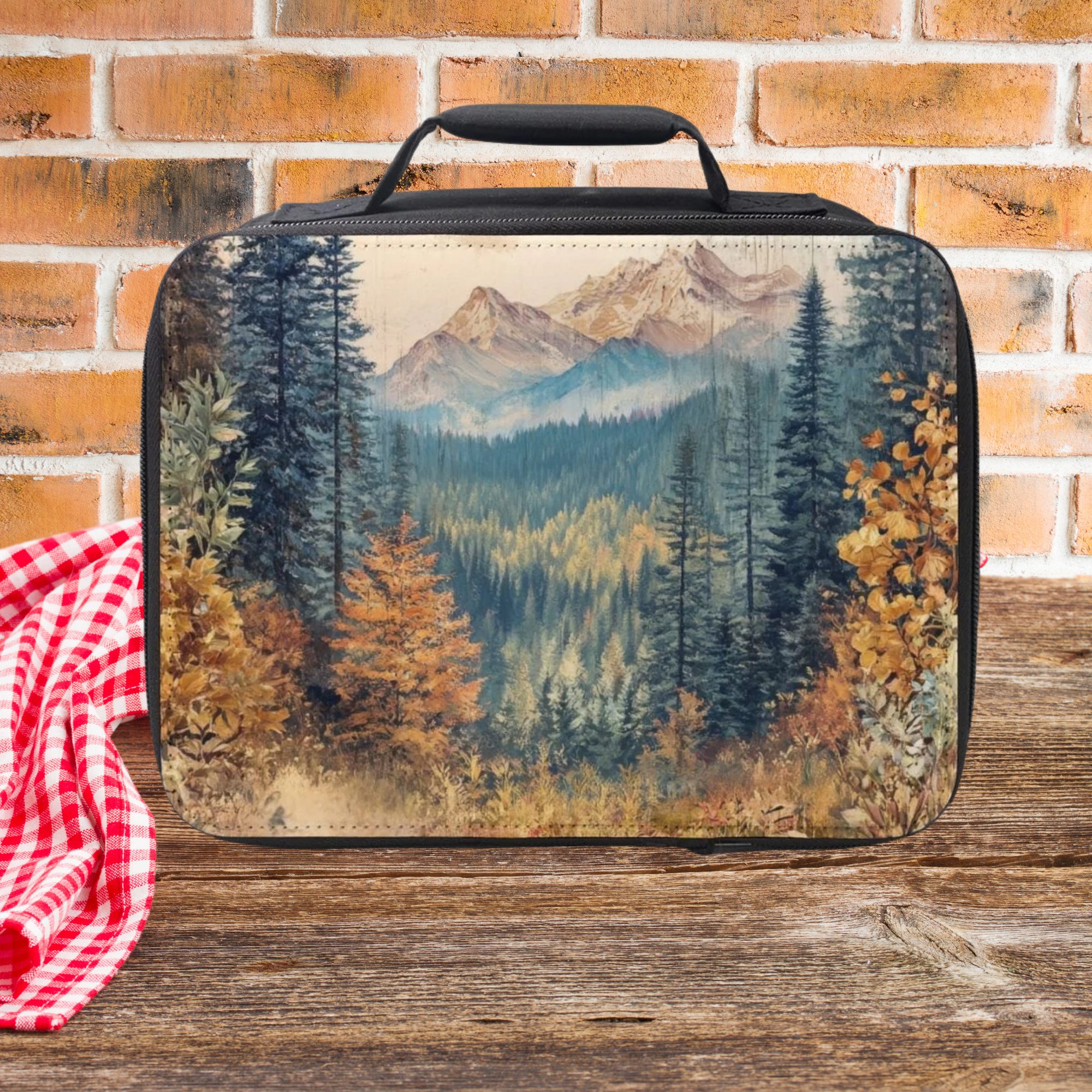 Lunch bag with mountain and forest design on a wooden surface with a brick wall background