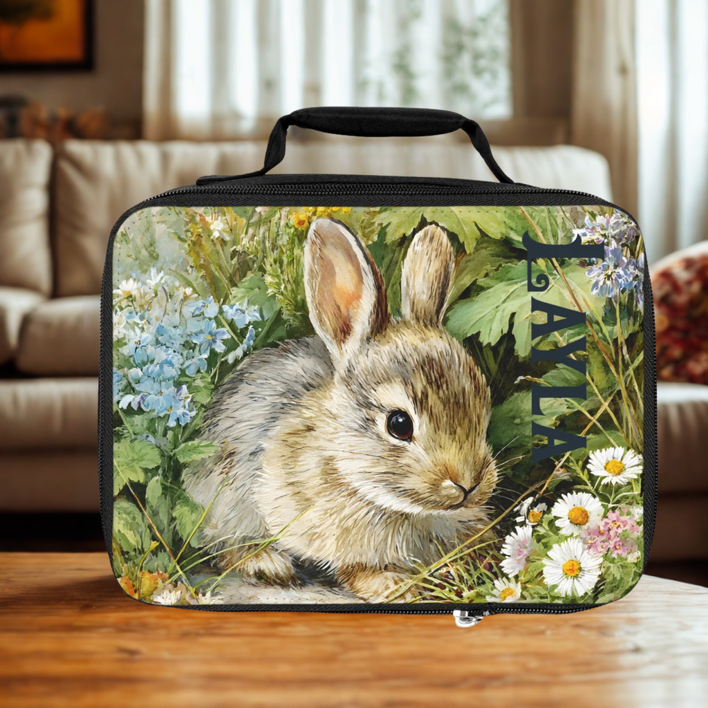  insulated lunch bag with a rabbit design and custom name 'Layla' on a wooden living room table.