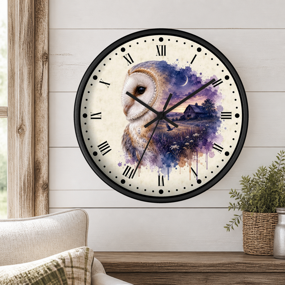 A round wall clock with a black frame and a watercolor-style owl illustration in purple, blue, and cream tones, mounted on a white shiplap wall above a wooden mantel with a plant and part of a sofa visible.