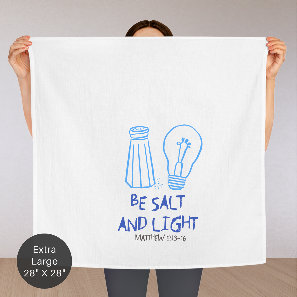 Person holding a large white towel with blue illustrations and text on a plain background