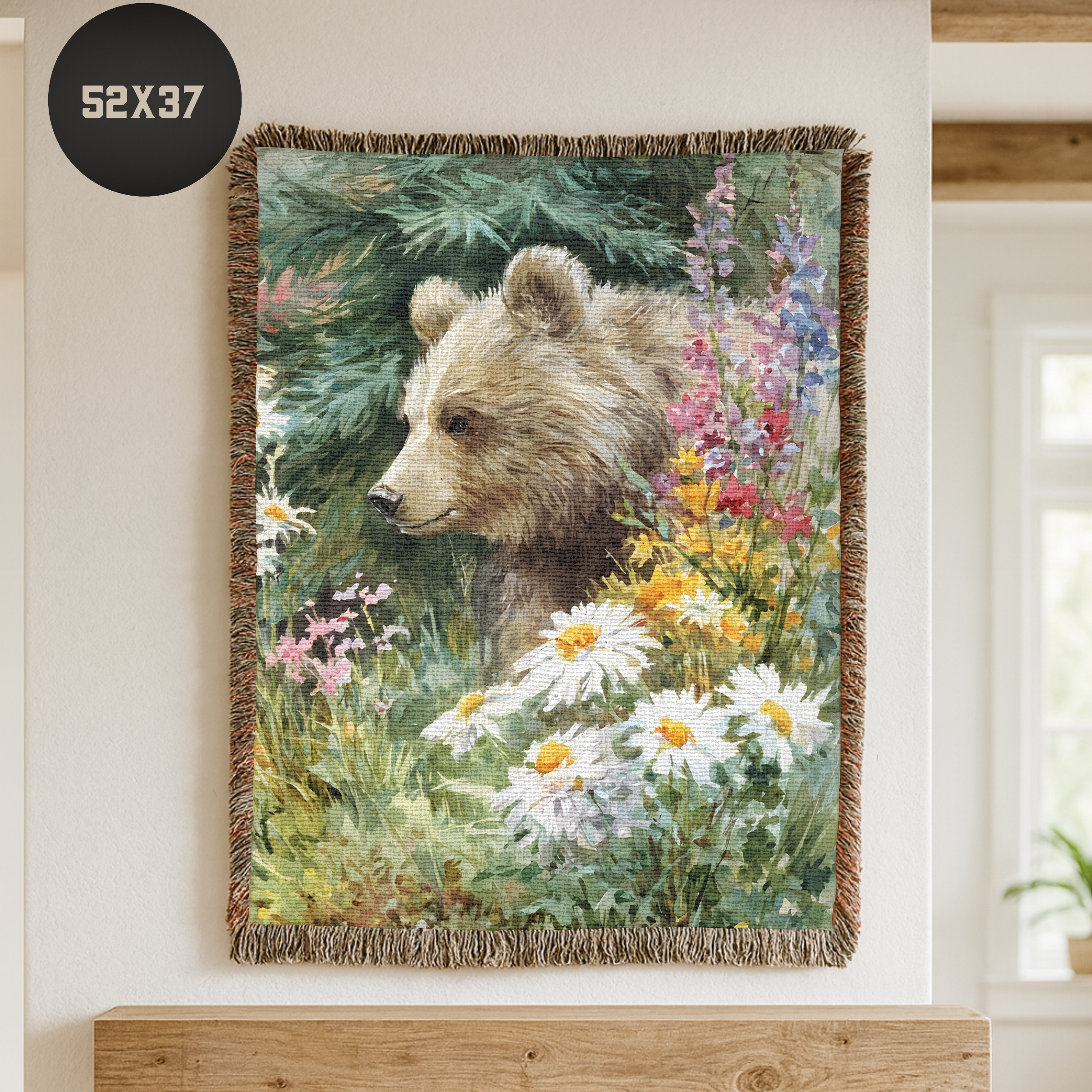 Woven blanket with a bear and floral design hanging on a wall.