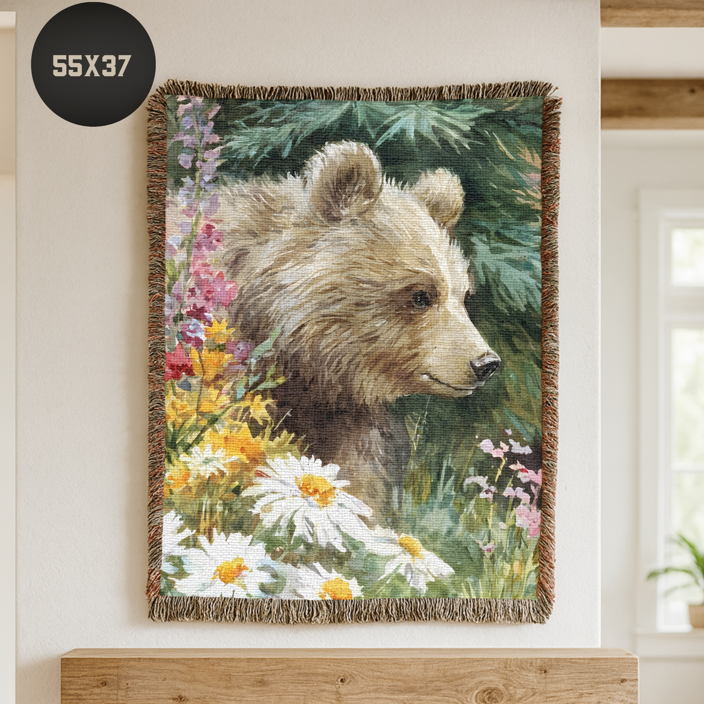 Woven blanket with a bear and floral design hanging on a wall.