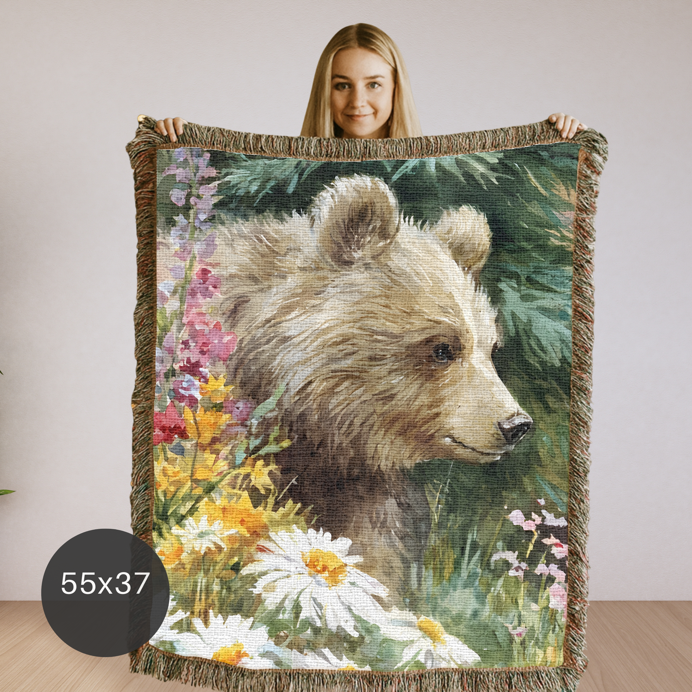 Woman holding a woven blanket with a bear and floral design