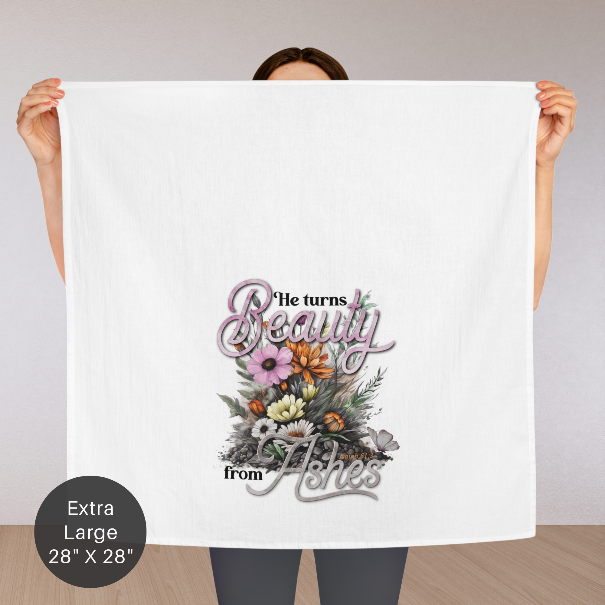 Person holding an extra large white tea towel with floral design and text.