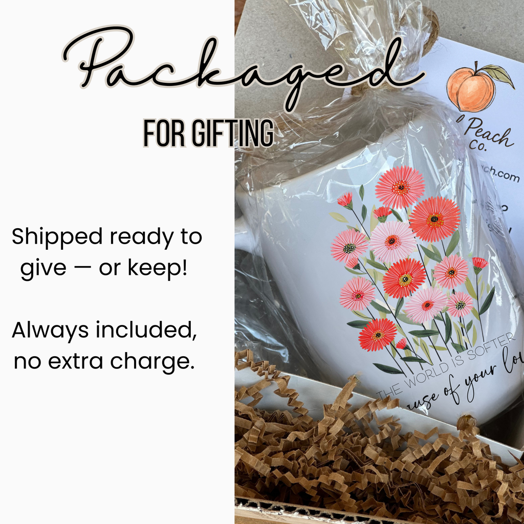 15oz white mug with floral design in a clear gift bag and a white gift box with brown shredded paper, labeled packaged for gifting.